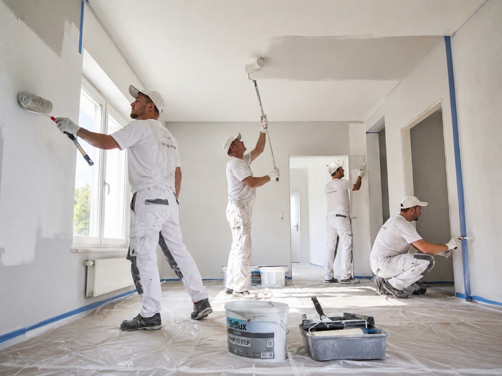 Maler bei der Arbeit – professionelles Team streicht Wände und Decken mit Farbroller in Berlin